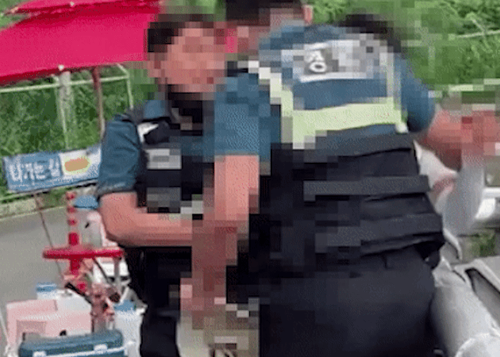 경남 양산경찰서 경찰관들이 16일 양산 평산마을 문 전 대통령 사저 앞 도로에서 시위를 해왔던 1인 시위자 A씨를 특수협박 혐의로 체포하고 있다./짝찌TV