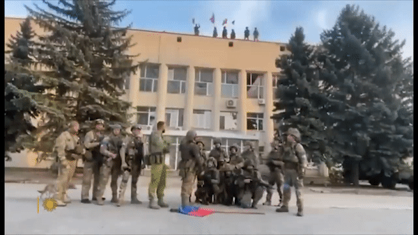 우크라이나군이 1일(현지시간) 탈환한 도네츠크주 북부 리만의 청사 앞에서 러시아 국기를 바닥에 버린 뒤 성명을 발표하고 있다. [유튜브 'CBS News' 채널 캡처]