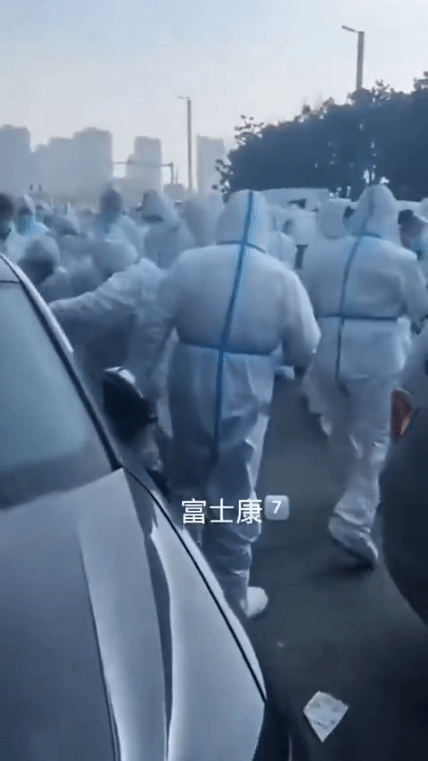 중국 장저우 폭스콘 공장 노동자 시위를 진압하던 보안요원들이 한 남성울 둘러싼 채 발로 밟고 있다. /ⓒ트위터 캡처