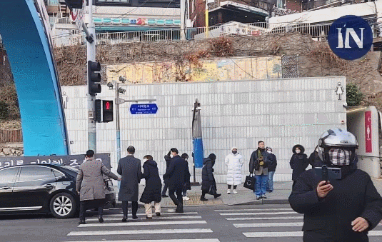 한덕수 국무총리가 19일 10·29 참사(이태원 참사) 희생자 합동분향소를 찾았다가 유족들 항의로 자리를 뜨며 빨간신호등이 켜져 있는 도로를 건너는 모습. 시사In TV 캡처