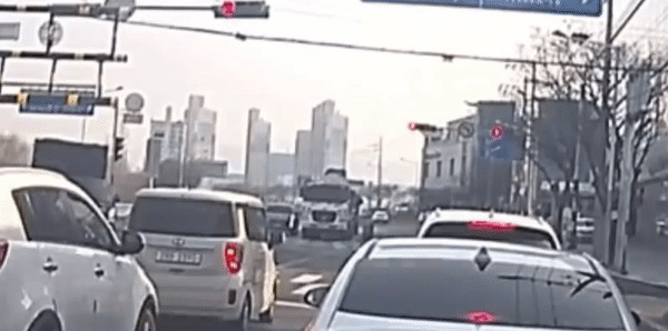 교차로에서 신호 대기 중이던 한 트럭에서 운전자가 지붕 위에 올라가 비보잉을 하고 있다. (한문철 TV)