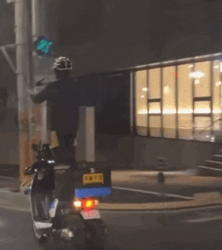 한 배달원이 달리는 삼륜 오토바이를 서서 타고 있다./ 온라인 커뮤니티