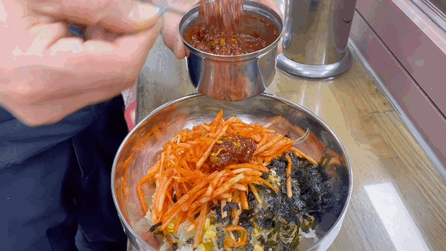 콩나물비빔밥에 양념장을 살짝 더해 비비는 모습. (영상=송혜수 기자)