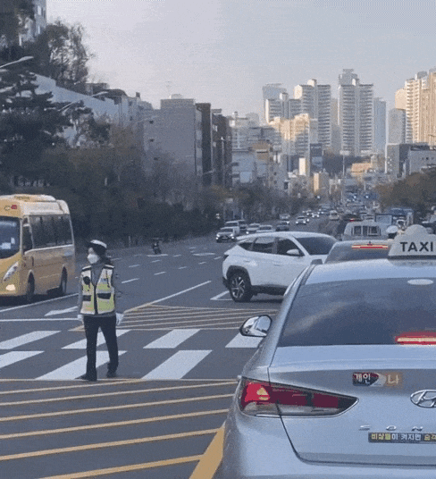 남녀 교통경찰이 서울 동작구 상도역 주변 도로에서 뒷짐을 진 채 근무를 서고 있다. 온라인 커뮤니티 캡처