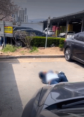 지난 1일 부산 해운대구 반여농산물도매시장 야외 주차장에서 주차 자리를 맡기 위해 바닥에 드러누운 여성. 온라인 커뮤니티 캡처