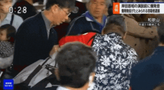 15일 기시다 일본 총리를 겨냥한 폭발물 테러 현장에서 붉은 옷을 입은 50대 어부가 용의자를 제압하고 있다. NHK 영상 캡처