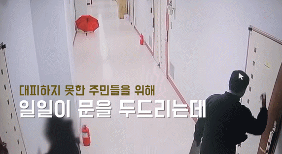 부산 북부경찰서 김동희 형사와 한 주민이 다른 주민들의 대피를 돕기 위해 문을 두드리고 있다. 유튜브 채널 경찰청 영상 캡처