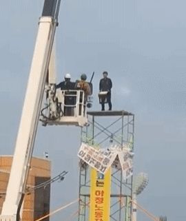 고공 농성 중인 조합원이 사다리차에 올라탄 경찰에게 의자를 던지고 있다. 전남경찰청