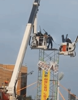 고공 농성 중인 조합원이 사다리차에 올라탄 경찰에게 쇠파이프를 휘두르고 있다. 전남경찰청