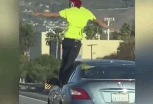 달리는 차 창문에 서서 팔을 벌리고 뒤를 돌아보는 남성. /KTLA