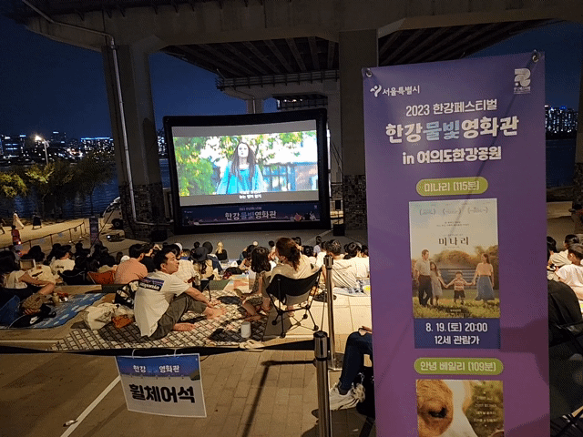 20일 밤 서울 여의도한강공원 원효대교 남단에서 ‘한강물빛영화관’의 영화 ‘안녕 베일리’가 상영되고 있다. 김용재 기자