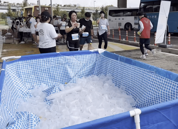 지난 17일 제17회 선사마라톤대회 제2급수대에서 수거함에 다회용컵을 버리는 참가자들. 주소현 기자