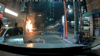 22일 오후 9시 40분께 부산 연제구 연산동의 한 교차로에서 택시에 불이 붙자 시민들이 소화기를 들고 불을 끄고 있다. [부산경찰청]