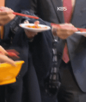 6일 정기선 HD현대 부회장이 부산 국제시장에서 떡볶이를 먹고 있다. /KBS 캡처