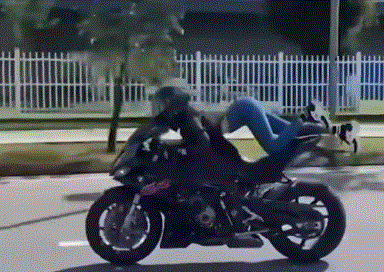 오토바이 위에 완전히 엎드린 채 곡예 운전을 하고 있는 베트남 모델 쩐 [영상 = SNS 갈무리]