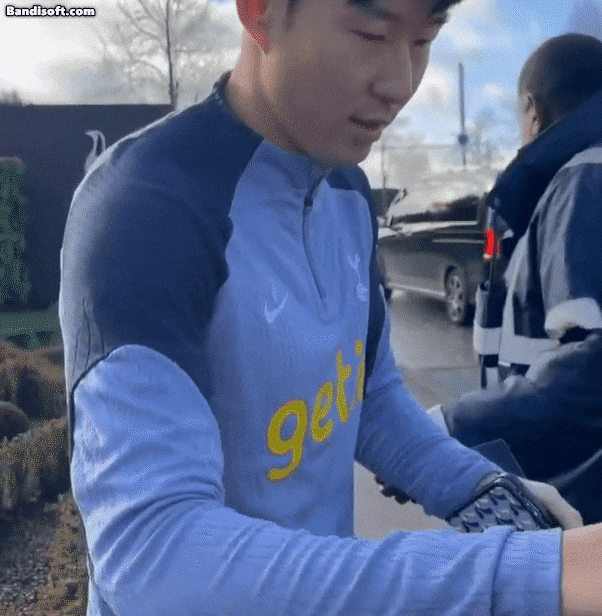 한국 대표팀 주장 손흥민(32·토트넘)이 이강인(23·파리 생제르맹)등과 물리적 충돌 과정에서 손가락이 탈구된 것으로 알려진 가운데, 팬에게 사인을 해주는 도중 후유증으로 인한 고통을 느끼는 모습이 포착됐다. [사진=온라인 커뮤니티]