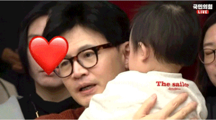 한동훈 국민의힘 비상대책위원장이 아기를 안자 아이가 한 위원장의 안경을 벗기는 모습.(사진=온라인 커뮤니티)
