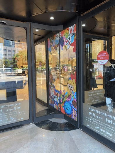 The main revolving door at Shinsegae Department Store's Gangnam branch features children's drawings as part of the campaign The Greatest Gift of All. [SEO JI-EUN]