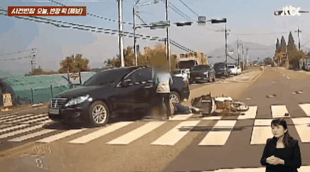 차에 치인 오토바이 운전자가 바닥에 쓰러진 상황임에도 사진을 찍는 승용차 운전자의 모습. /영상=JTBC '사건반장'