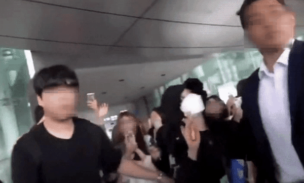 가수 겸 배우 아이유가 동선 확보를 위해 팬들을 밀치는 경호원을 제지하는 모습. /사진=온라인 커뮤니티 캡처