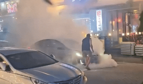 온라인 커뮤니티 '에펨코리아'에 올라온 용인 테슬라 화재 모습. 한 남성이 바퀴에 소화기를 뿌리고 있다./ 온라인 커뮤니티