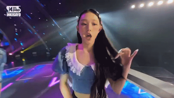 SBS 인기가요 무대 중 뉴진스의 아이폰 광고 논란 장면. 아이폰을 꺼내 사진을 찍는 퍼포먼스를 펼쳐 논란이 일었다. [SBS 방송 캡처]