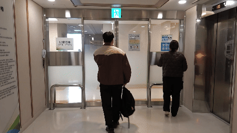 기자가 백혈구촉진제 투약 후 조혈모세포은행 코디네이터의 안내를 받아 여의도성모병원 병실로 들어가고 있다. 영상=정혜미 PD