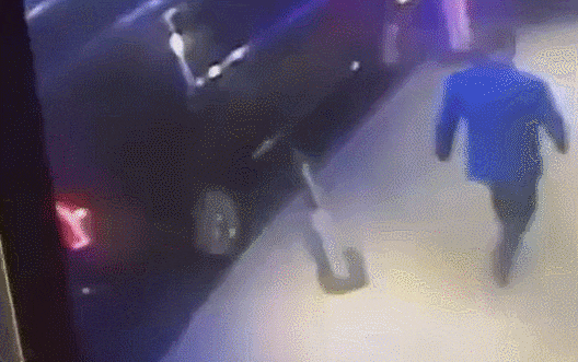 총격 순간이 담긴 방범 카메라 영상. 모자를 뒤집어 쓴 범인이 앞서 가는 톰슨 뒤를 밟으며 총을 쏘고 있다. /X(옛 트위터)