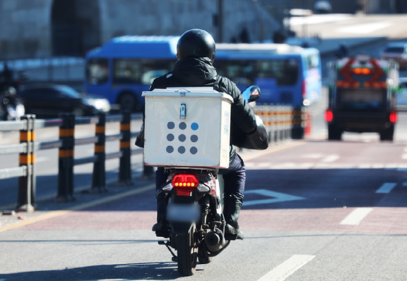 오토바이를 탄 배달원이 도로를 달리고 있다. [사진=연합뉴스]