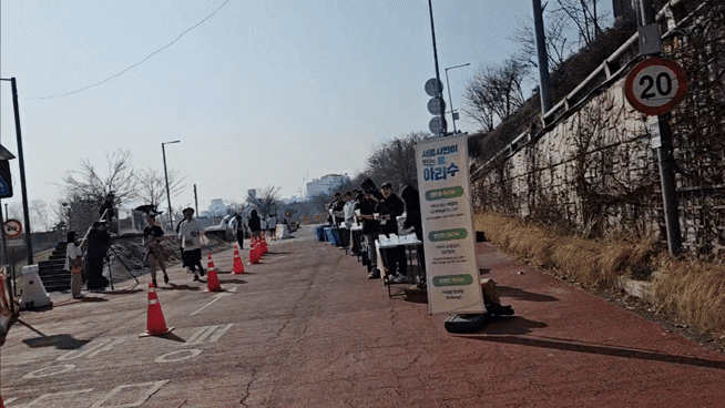 23일 오전 서울 여의도 한강공원에서 열린 ‘2025 무해런’ 급수대에서 다회용기에 담긴 물을 나눠주고 있다. 김광우 기자.