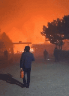 교도관이 소화기를 들고 산불을 진화하러 가고 있다. [온라인 커뮤니티]