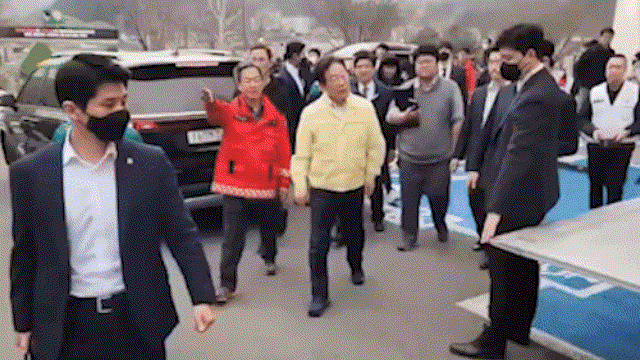 27일 경북 영양군 이재민 대피소 인근에서 검은 옷을 입은 남성이 더불어민주당 이재명 대표를 향해 옷을 휘두르는 모습. 연합뉴스TV 캡처