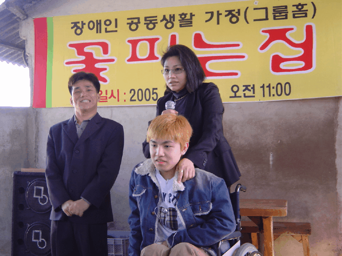 In 2005, 18-year-old Jang Ik-seon (seated) attends an event at a disability group home, a shared living space designed to provide support and independence for people with disabilities. (Courtesy of Jang Ik-seon)