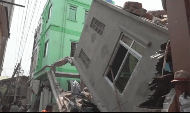 무너진 건물 옆으로 주민들이 뒷정리를 하고 있다.