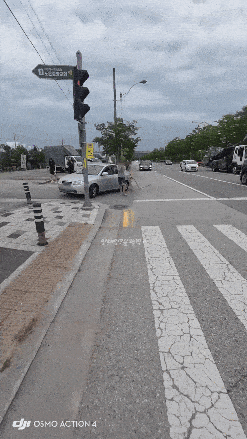 오토바이의 주의로 차량을 갓길에 세운 운전자가 태연하게 주유구로 다가가 주유건을 뽑고 있다. [보배드림 갈무리]