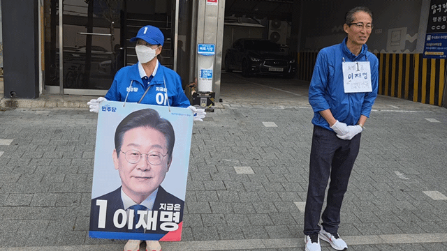 28일 오전 7시 30분께 서울 동대문구 답십리역 1번출구 인근에서 선거운동원 김관순(55, 왼쪽)씨가 이재명 더불어민주당 대선 후보에 대한 지지를 호소하며 출근길 유세에 나선 모습. /영상=이민형 기자