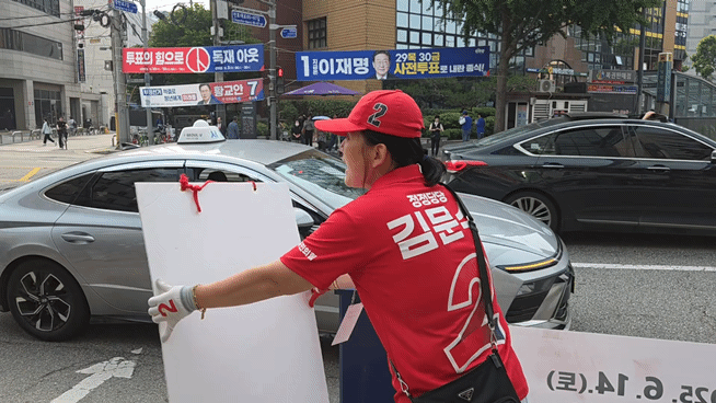 28일 오전 8시께 서울 동대문구 장한평역 5번 출구 인근에서 선거운동원 박미숙(60) 씨가 출근길 시민들을 상대로 김문수 국민의힘 대선 후보에 대한 지지를 호소하며 유세에 나선 모습. /영상=이민형 기자