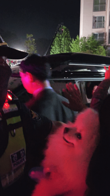 반려견을 안은 시민이 3일 인천 계양구 이재명 대통령 사저 앞에서 김혜경 여사에게 손을 흔들고 있다. ⓒ 뉴스1 최서윤 기자