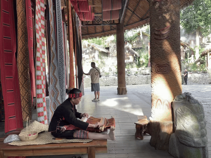 빙랑구 리족·먀오족 전통문화 마을에서 리족 할머니가 베틀로 직물을 짜고 있다. 그 옆엔 전통 방식으로 실을 짜 만든 직물이 널려 있다. /하이난(중국)=이은영 특파원