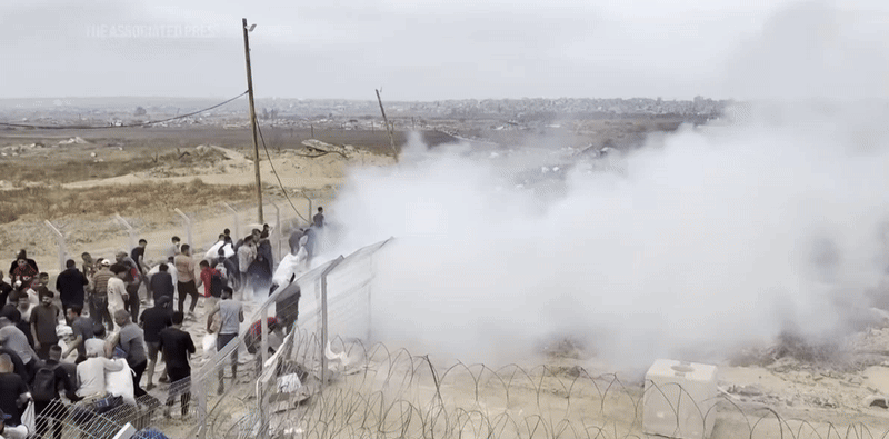 가자지구 GHF  배급소 인근에서 팔레스타인인들 사이로 섬광탄에서 나온 연기가 피어오르는 모습.  출처 AP통신 유튜브