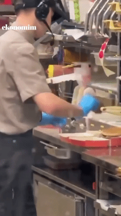 러시아의 패스트푸드 체인인 '테이스티닷' 매장에서 직원이 손님에게 줄 햄버거에 침을 뱉는 모습. <출처=엑스(X)>