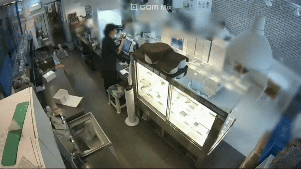 지난 26일 오후 제주도 서귀포시 한 카페에서 남성 손님이 두 번째로 내던진 베이글에 점주가 움찔하고 있다. 베이글은 뒤편 싱크대로 떨어졌다. 시청자 제공