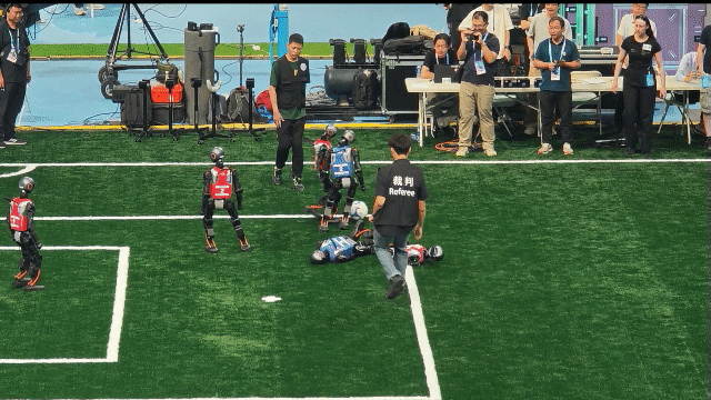 14일 세계휴머노이드로봇대회 개막식 전 진행된 5대5 로봇 축구 연습 경기. 로봇은 완전 자율 제어 상태로 경기를 진행하지만, 넘어져 일아나지 못할 경우 심판이나 팀 관계자가 끌어내 선수를 교체한다. 베이징=김철중 특파원 tnf@donga.com