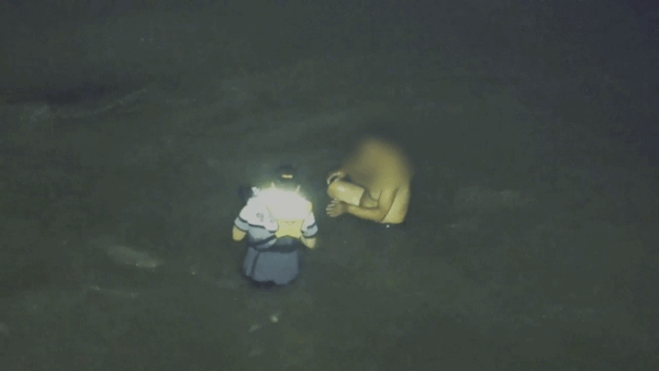 지난 11일 인천 옹진군 영흥도 갯벌에 고립된 중국 국적 남성에게 이재석 경사가 구명조끼를 벗어주는 모습.&nbsp;인천해양경찰서 제공