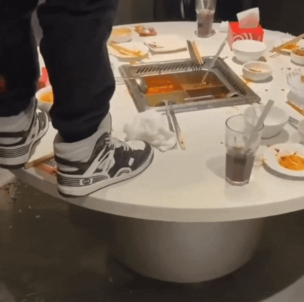 한 중국 남성이 상하이의 훠궈 전문점에서 테이블에 올라가 소변을 보고 있다./웨이보