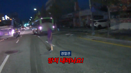 60대 남성이 대전 동구의 한 도로에서 망치를 들고 경찰관과 대치하고 있다. 대전경찰청 제공