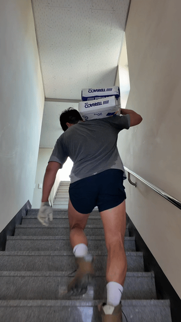 무인 모텔 리모델링 현장에서 하 씨의 남편이 인부들과 함께 시멘트 포대를 옮기고 있다.