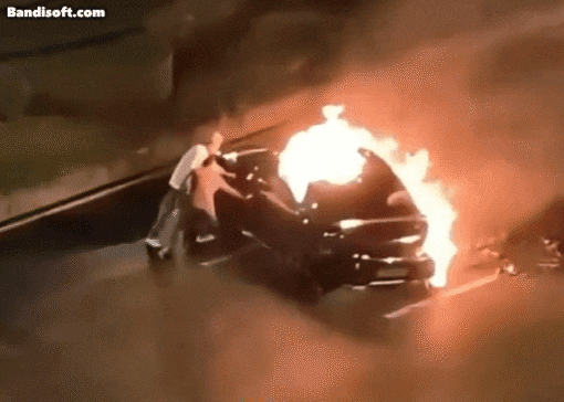 불이 난 샤오미 전기차에서 시민들이 운전자를 구조하려고 시도하지만 차문이 열리지 않는 모습./ 엑스(X)