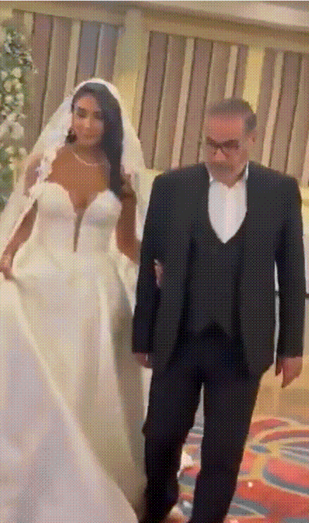 웨딩드레스를 입은 샴카니 딸이 아버지와 연회장에 들어서고 있다. /X