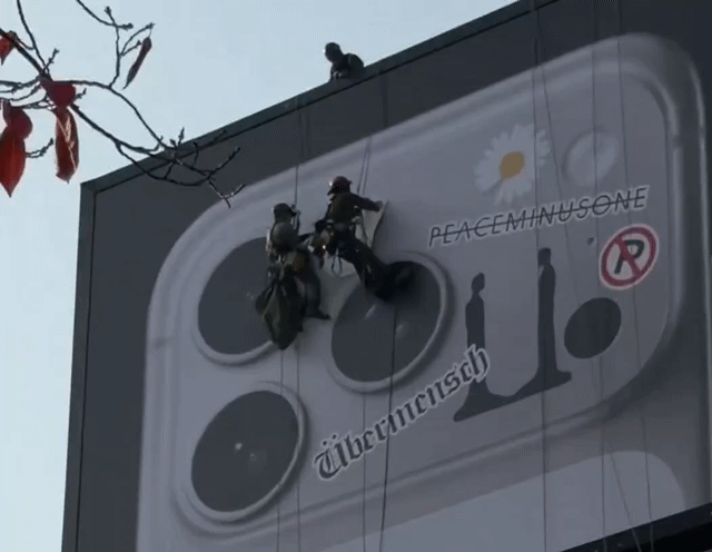 대형 옥외광고판에 걸린 아이폰17 프로 이미지 위로 지드래곤의 앨범·브랜드명이 붙은 모습. 영상=인스타그램 계정 'scrollpin' 갈무리